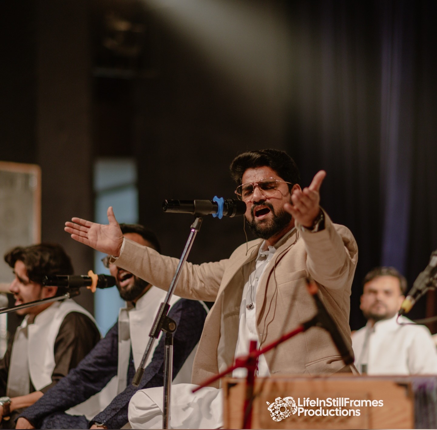 Faizan Ilahi, a renowned Sufi singer from Aligarh, performing on a dimly lit stage, creating a moody and soulful ambiance.